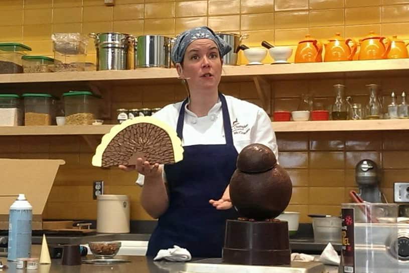 Emily holding a chocolate turkey during a sculpture demonstration